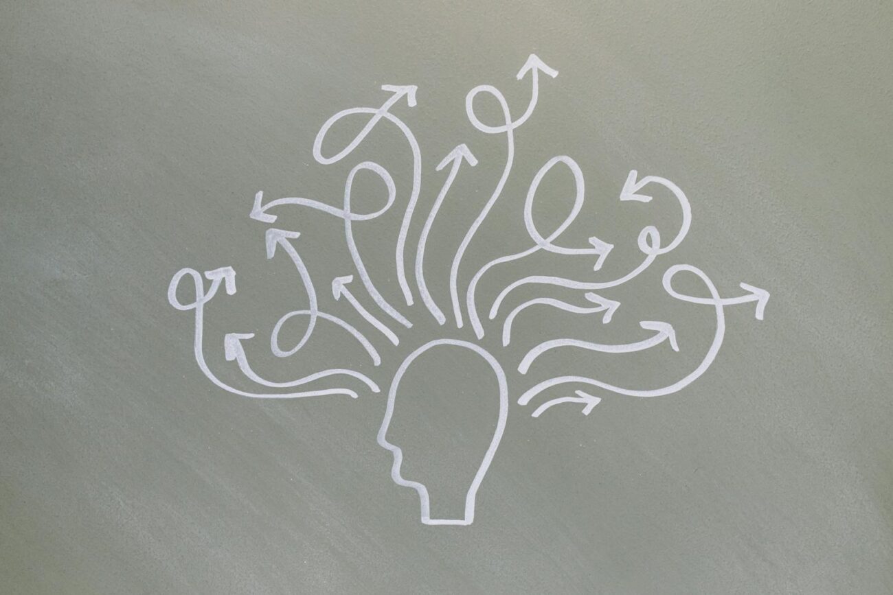 Conceptual chalk drawing illustrating mental health challenges with arrows representing thoughts.