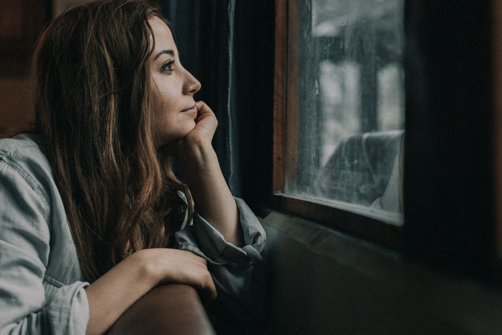 A person looking out a window, thoughtful and reflective