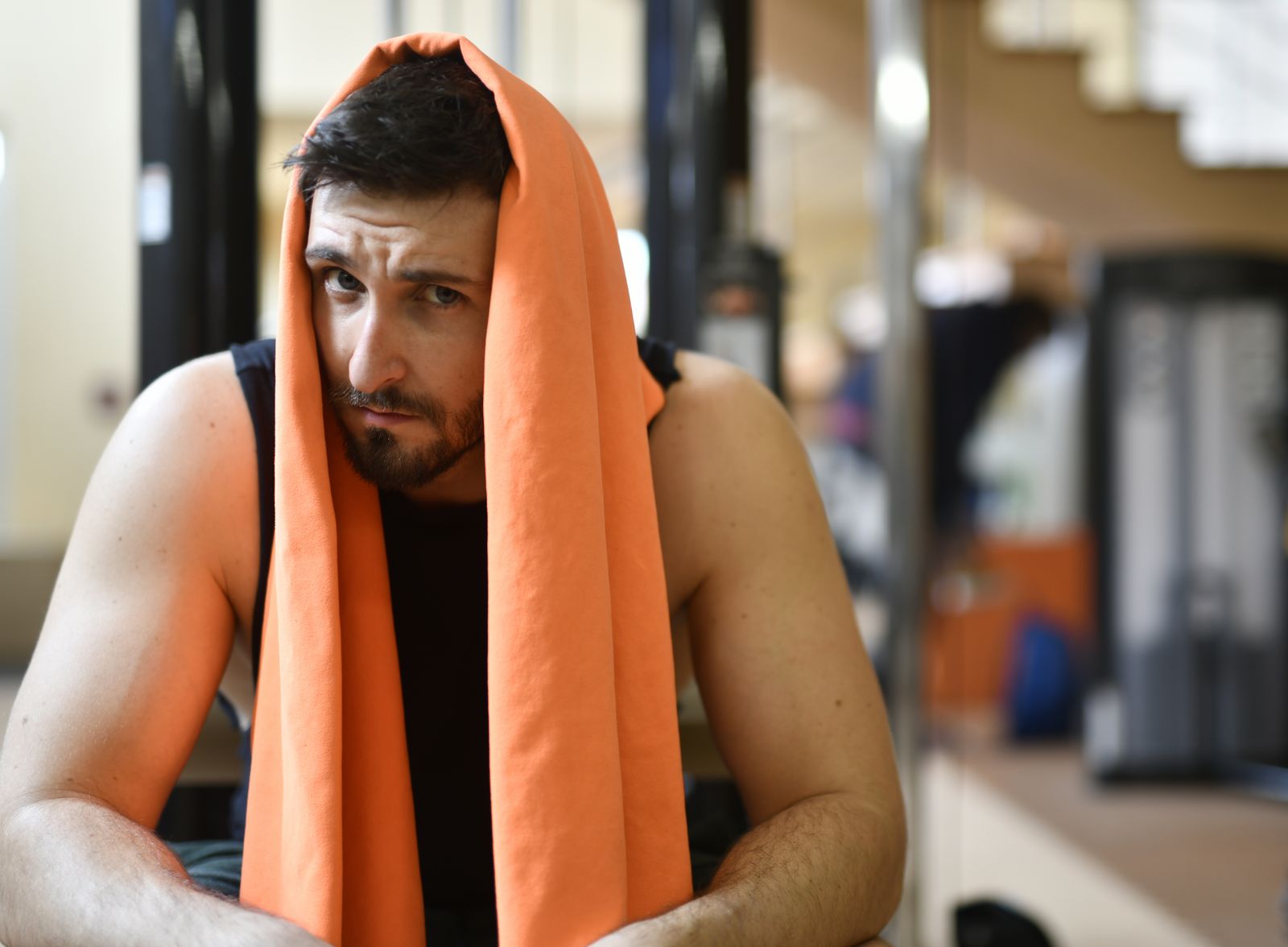 A tired person resting with a towel after an intense workout