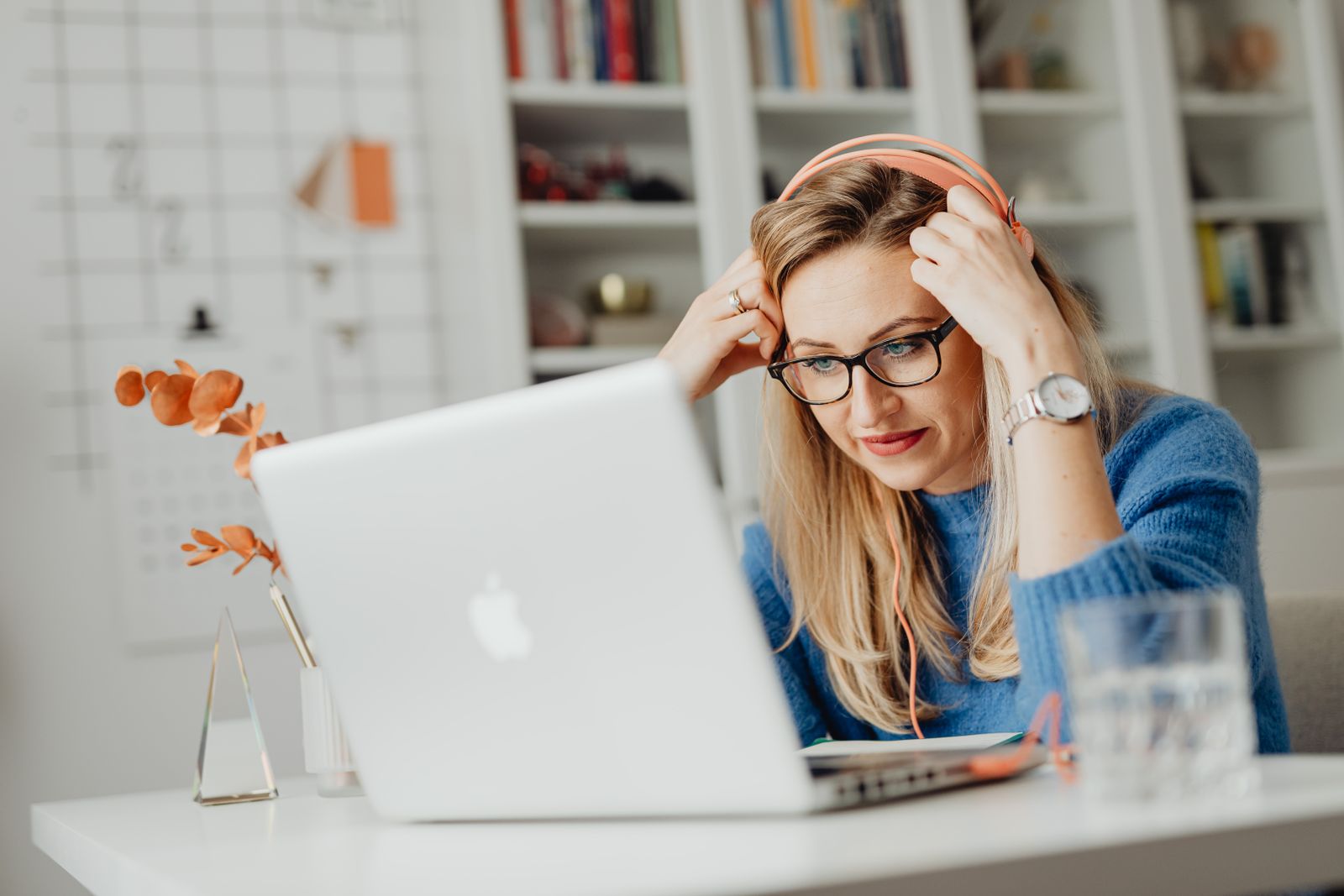 A person wearing headphones and focusing on a laptop screen