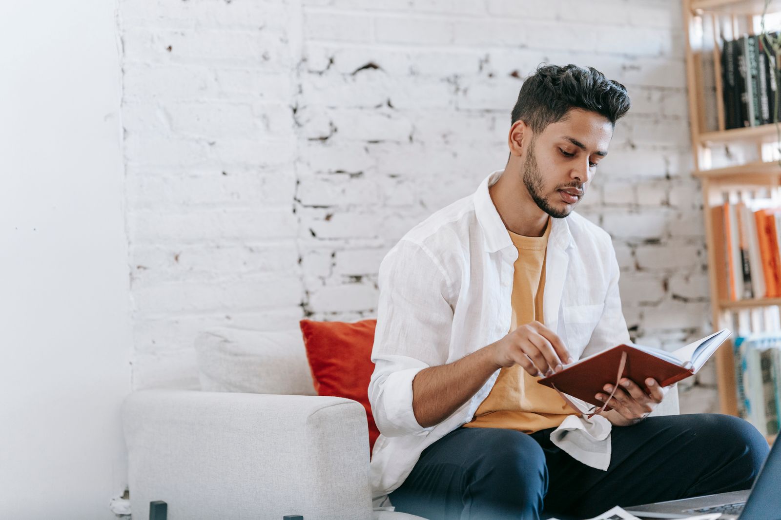 A person reading a book attentively in a calm home setting