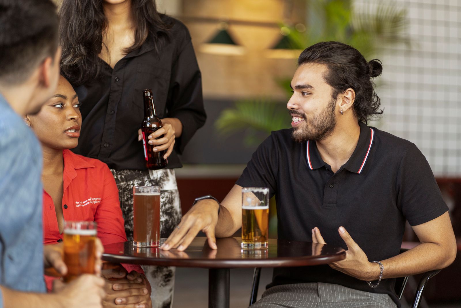 A group of adults talking around a table in a casual social setting