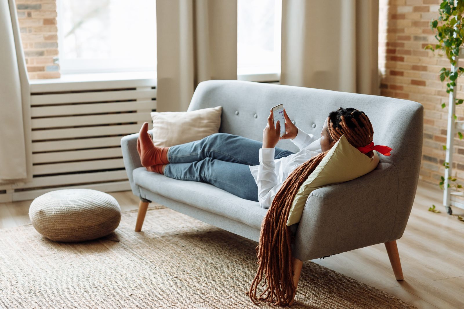 An adult lying on a couch with a phone, relaxing instead of starting anything