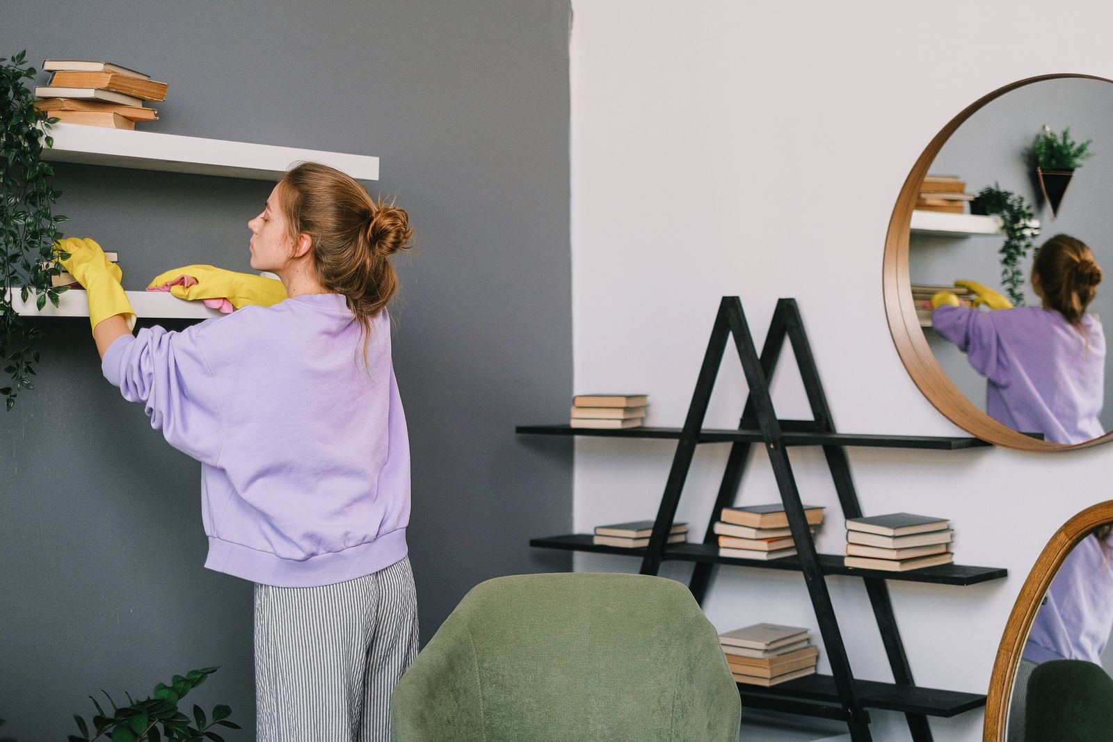 A person cleaning a shelf at home, doing a small part of the task